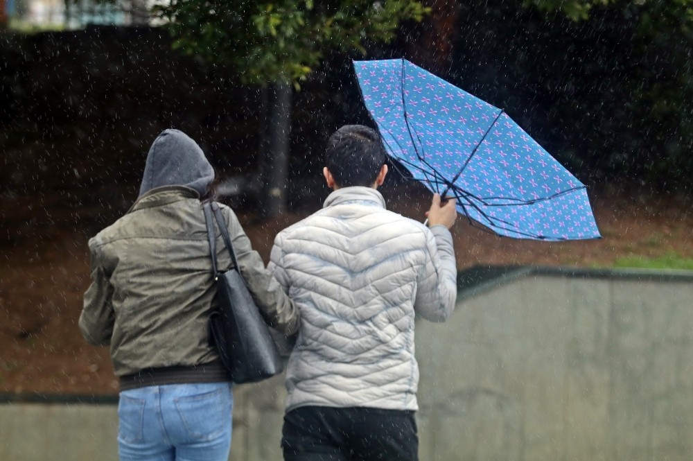 Yağmurdan korunmak için açılan şemsiyeler, fırtınayla tersine döndü 
