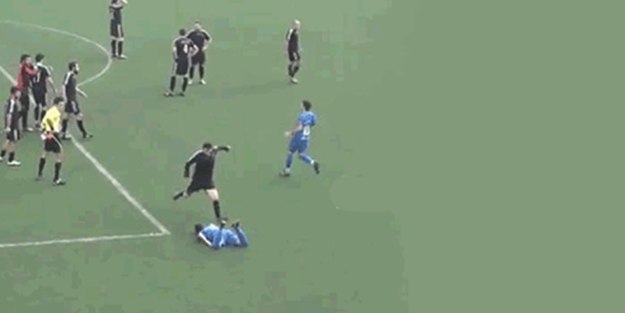 Yerde yatan futbolcunun kafasına tekme