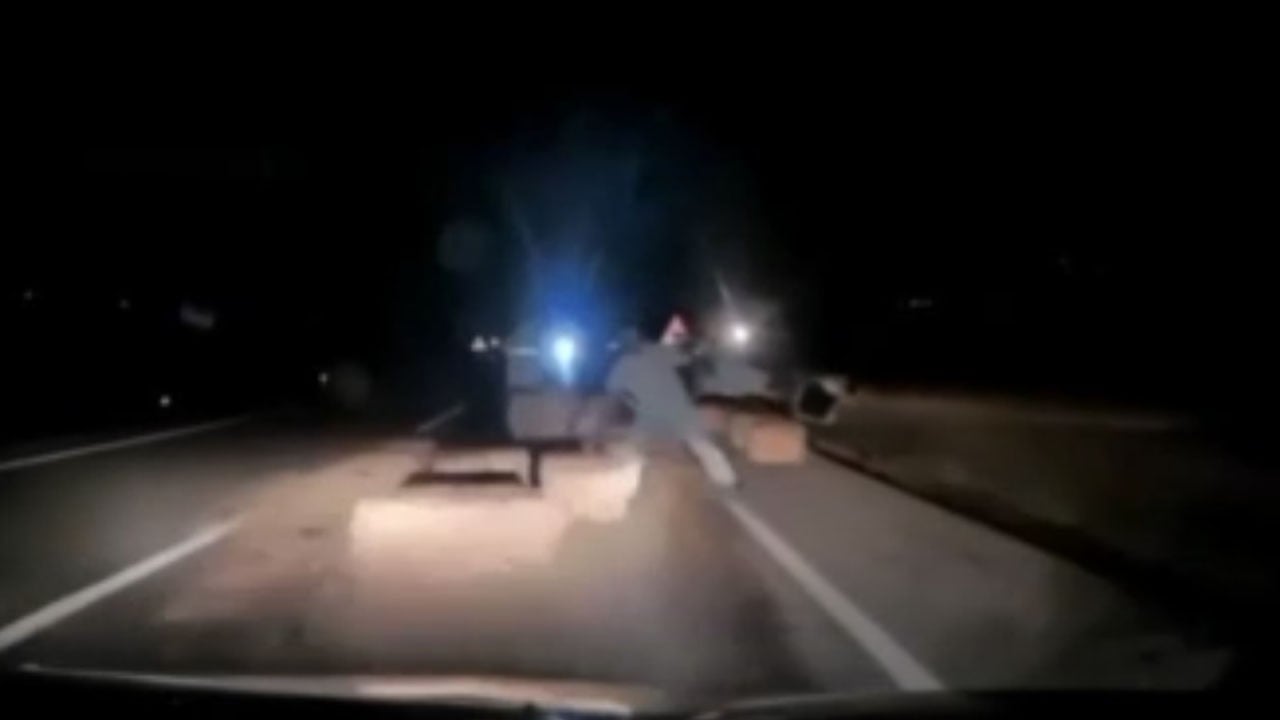 Yolda kaza uyarısı için saman balyası koyarken otomobilin altında kaldı