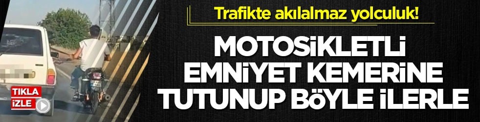 Trafikte akılalmaz yolculuk! Motosikletli emniyet kemerine tutunup böyle ilerledi