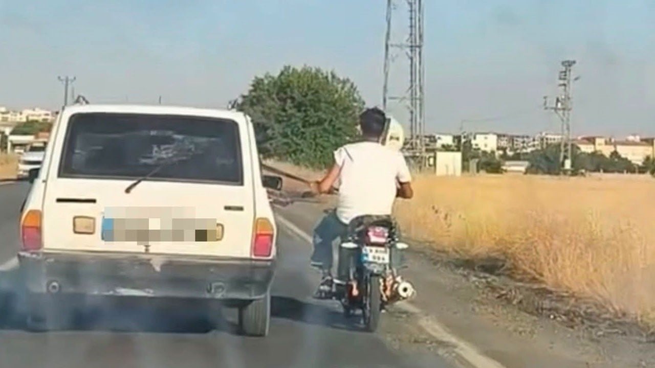 Trafikte akılalmaz yolculuk! Motosikletli emniyet kemerine tutunup böyle ilerledi
